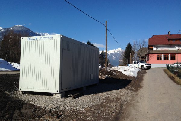 Baucontainer mit PickUp im Hintergrund